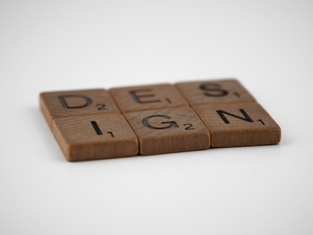 brown wooden scrabble pieces laid out to spell the word design